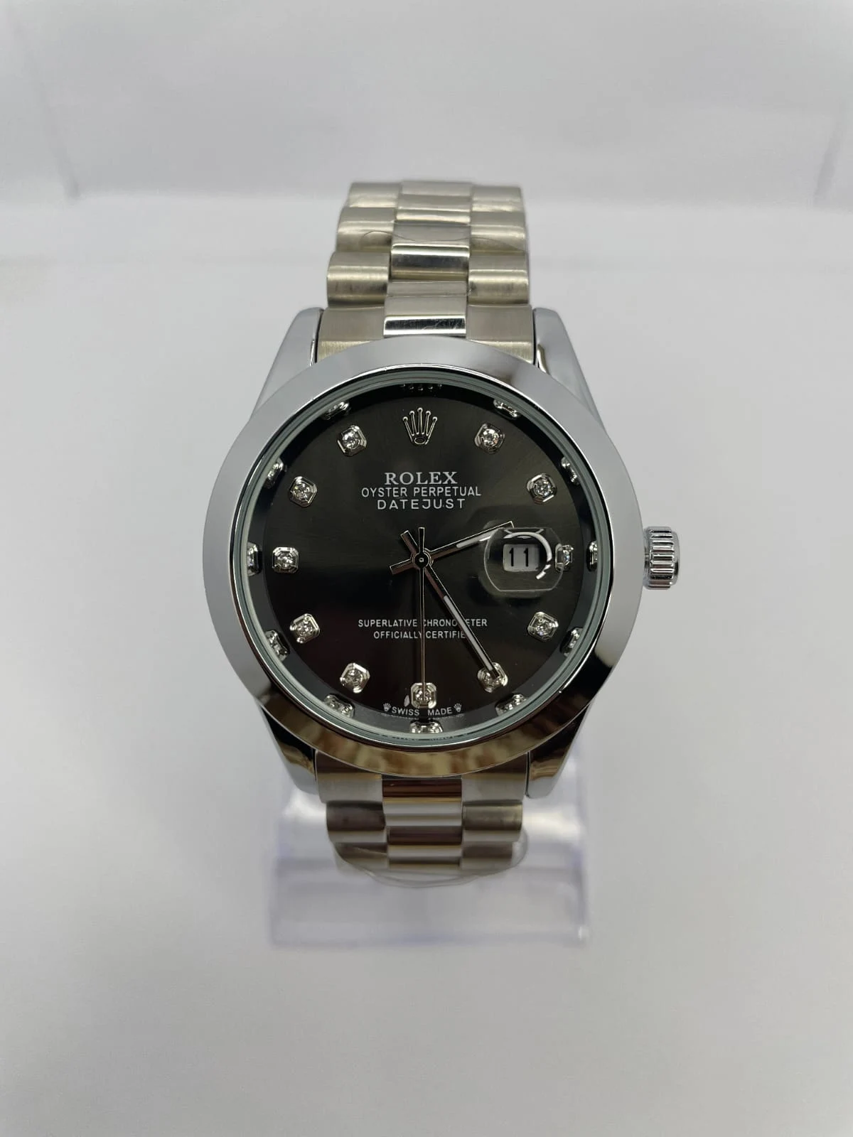 Rolex Datejust watch with black dial, diamond hour markers.
